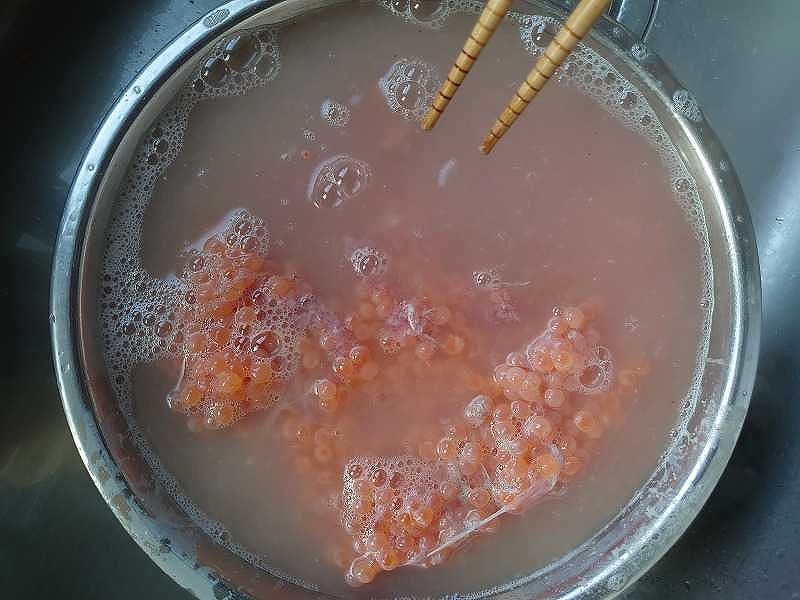 ボウルに入れたイクラに熱湯をかける様子
