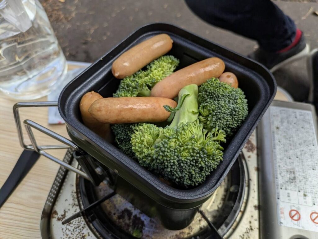 クッカーの蒸し器にブロッコリーとソーセージを入れた画像
