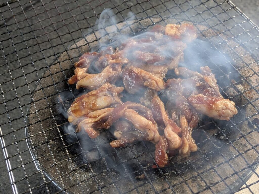 揉み込んだジンギスカンを炭火で焼いている様子