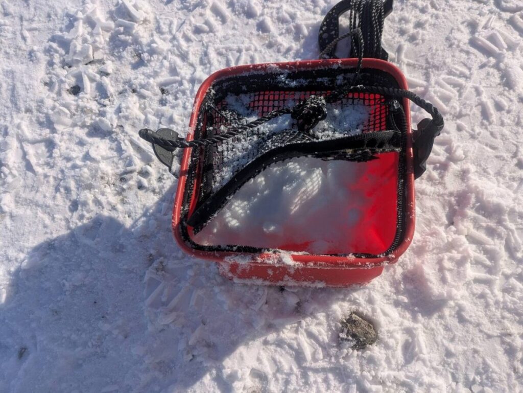 魚の入ったバケツに雪を被せた画像