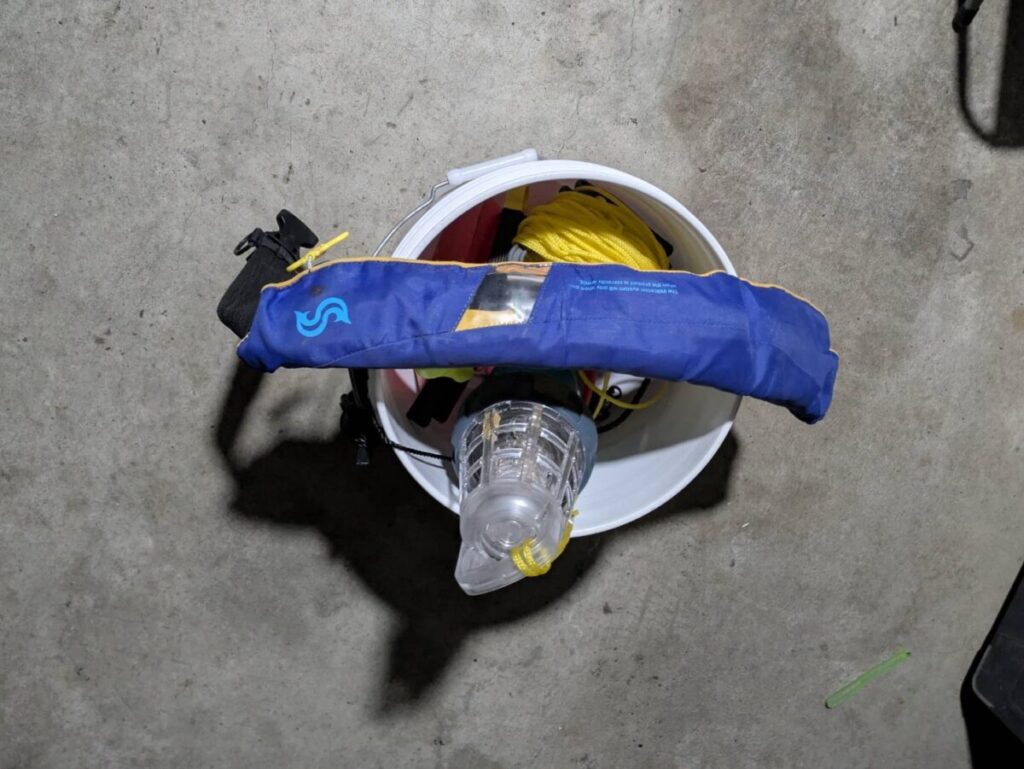 バケツに詰め込んだ釣り道具とライフジャケット