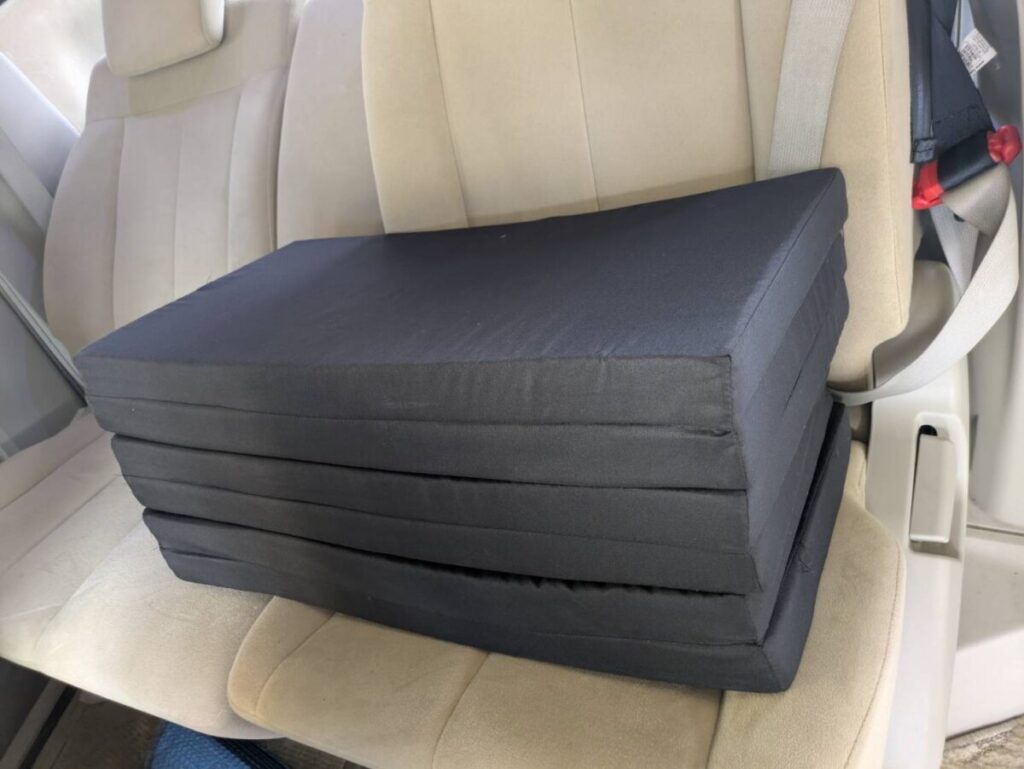 車のシートの上に置かれたアキレスの車中泊マット