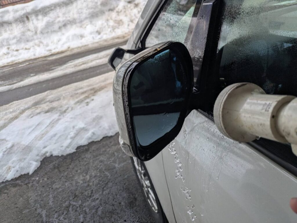水をかけても水滴にならず親水コートが完了しているサイドミラー