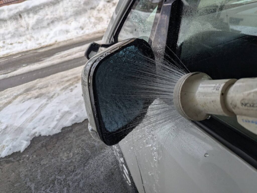 サイドミラーにシャワーで水をかける画像