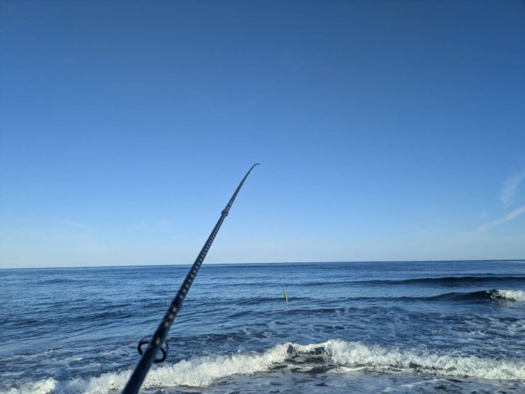 日本海のサーフで釣り竿を持っている様子
