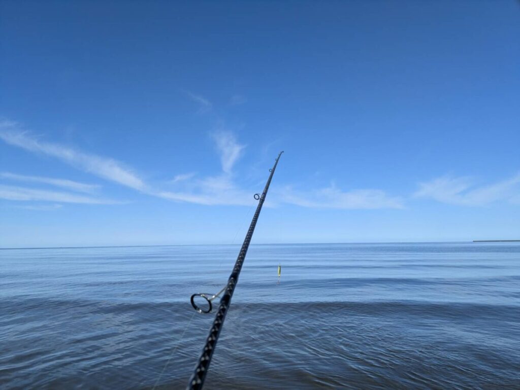 日本海のサーフで釣り竿を持っている様子
