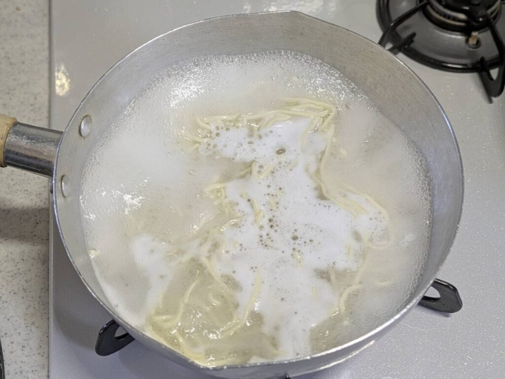 乾麺を雪平鍋で茹でている様子画像