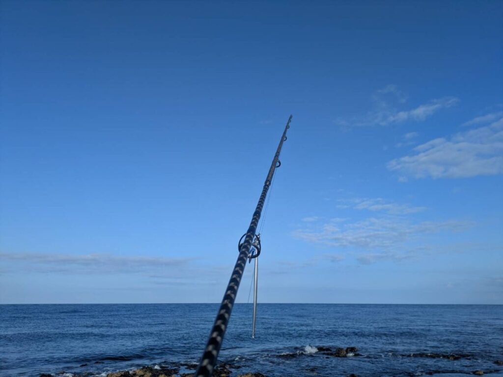 シマノコルトスナイパーロングをセッティングして海に構えている画像